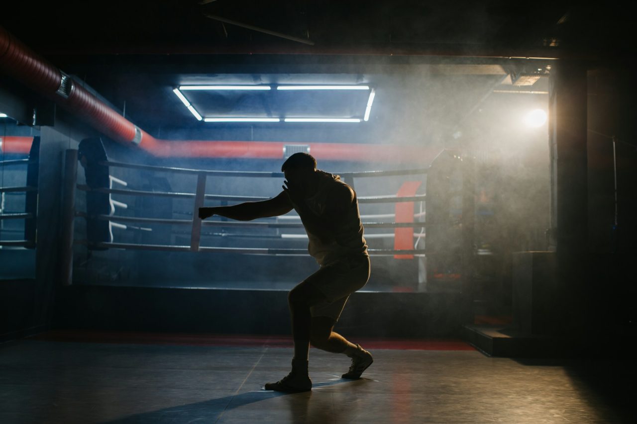 a-male-boxer-is-boxing-with-a-shadow-on-the-background-of-a-boxing-ring-.jpg