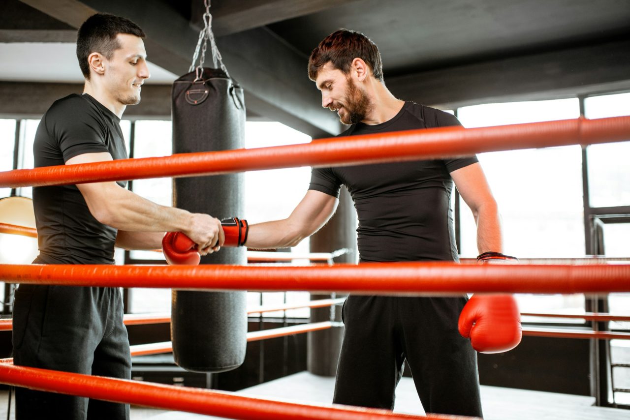 boxing-trainer-helping-man-durnig-the-boxing-training.jpg